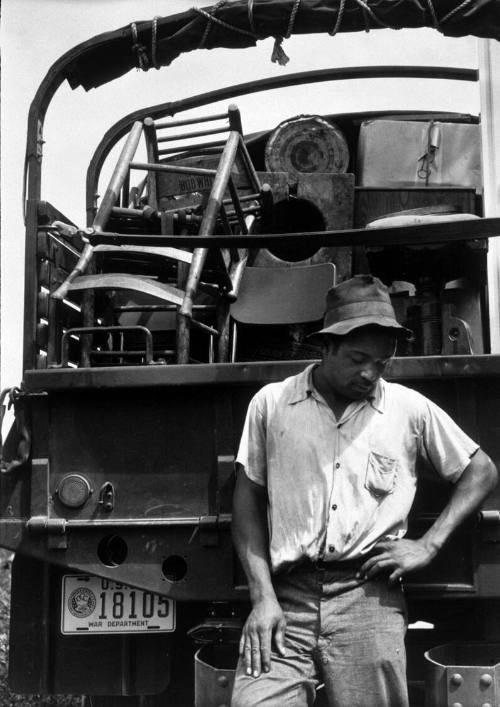 Civilian Conservation Corps Trucks are Helping this Young Man's Family Move Their Belongings Out of the Area Being Taken Over by the Army